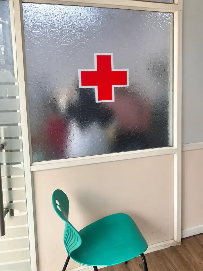 Frosted-glass door of the consultation room, marked with a red cross